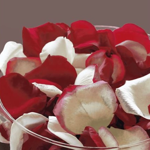 Una fuente de vidrio llena de petalos de rosa en su interior
